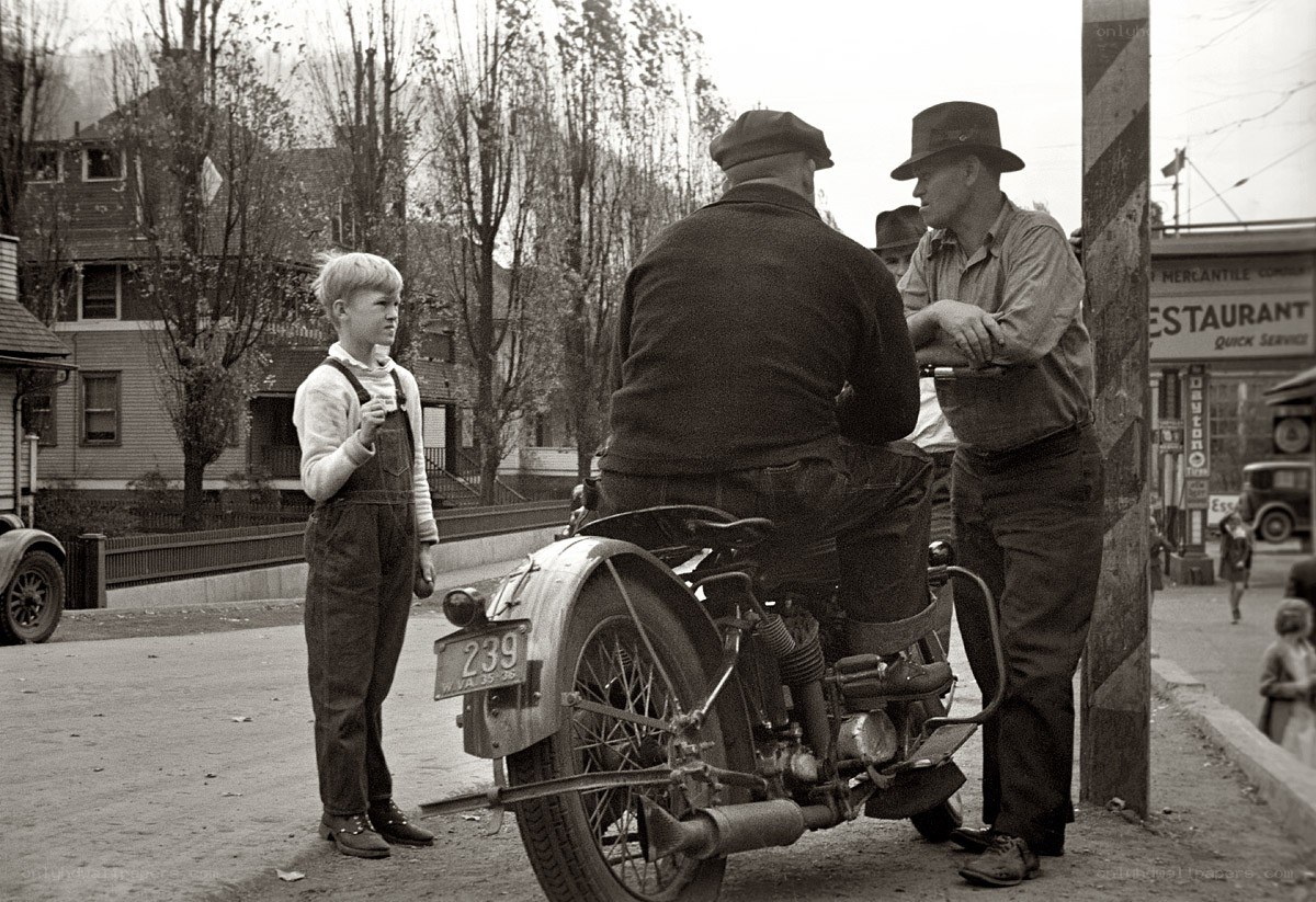 Boy talking to men by motorcycle