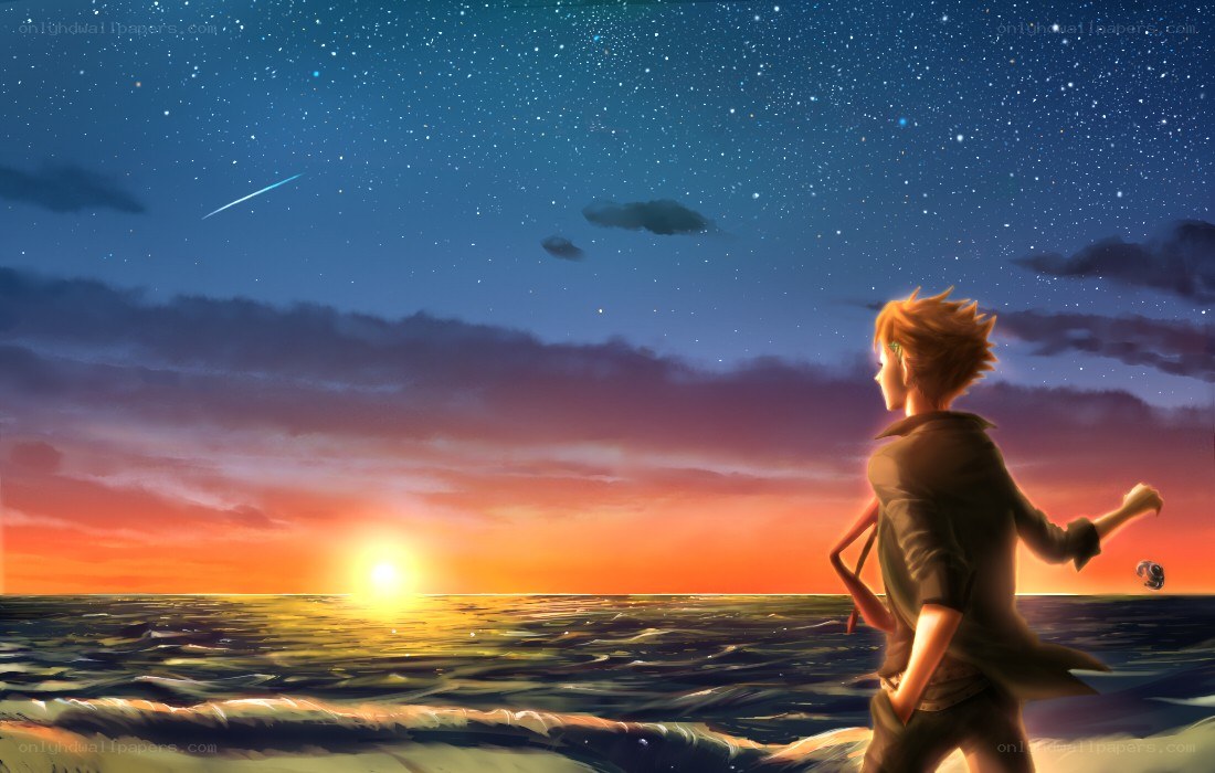 Boy watching sunset over ocean