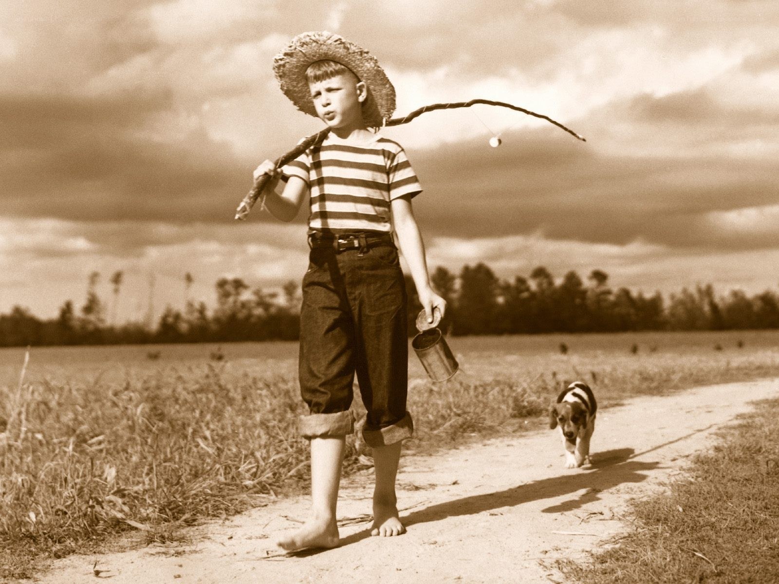 Boy with fishing pole and dog