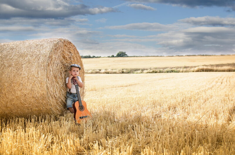 Boy with Guitar in Field