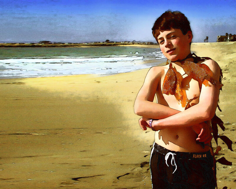 Boy with seaweed on beach