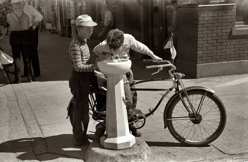 Boys drinking from a water fountain