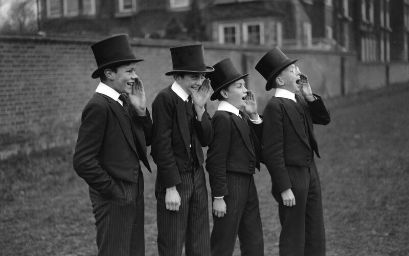 Boys in top hats whispering