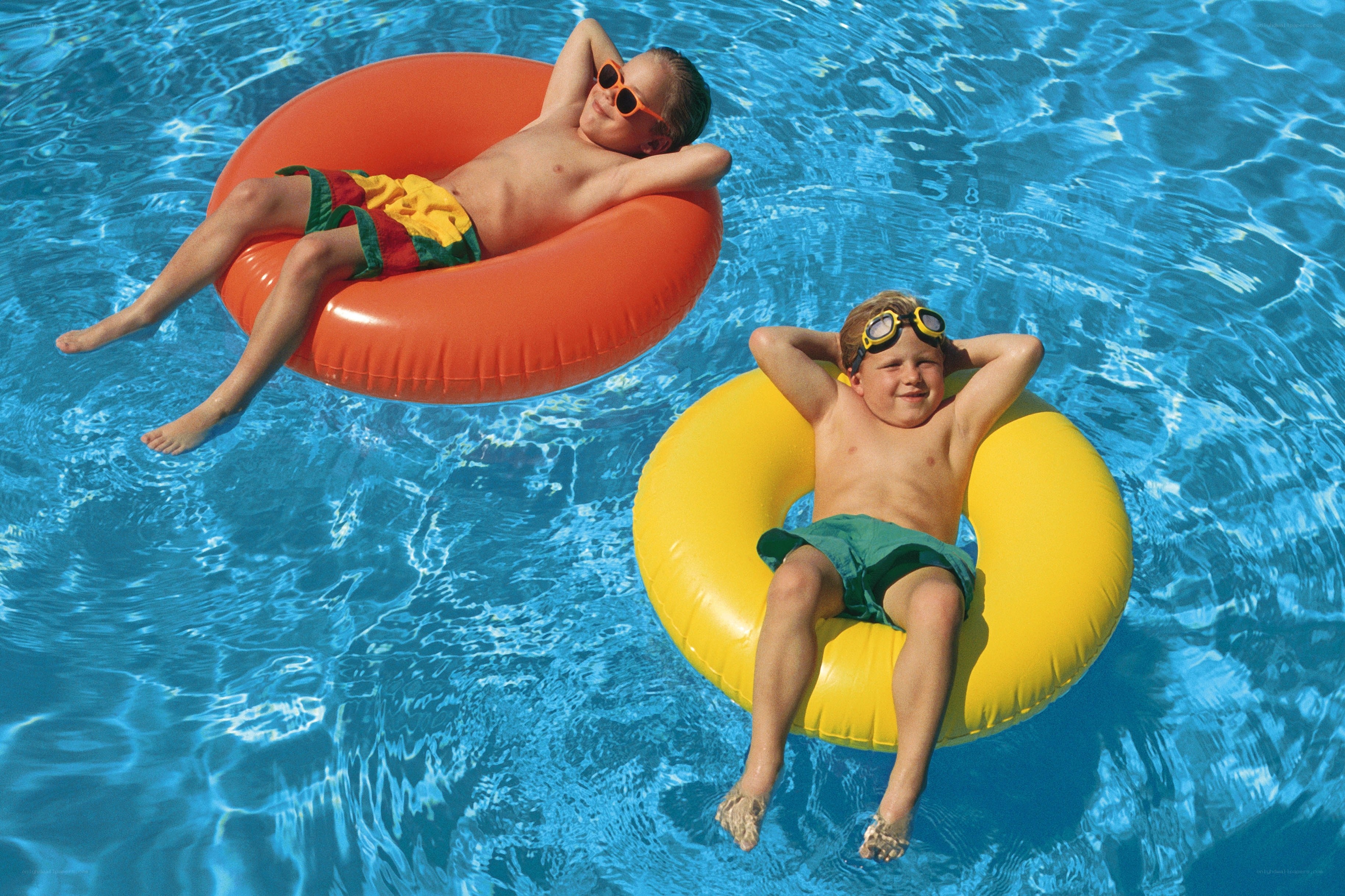 Boys relaxing in pool floats