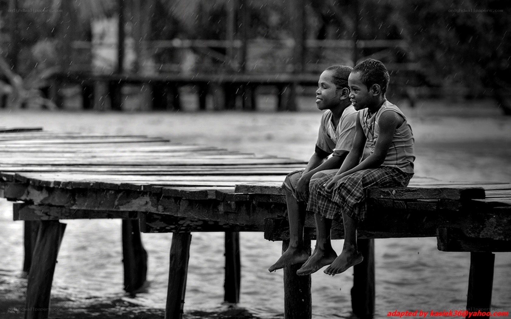 boys sitting on a dock in rain