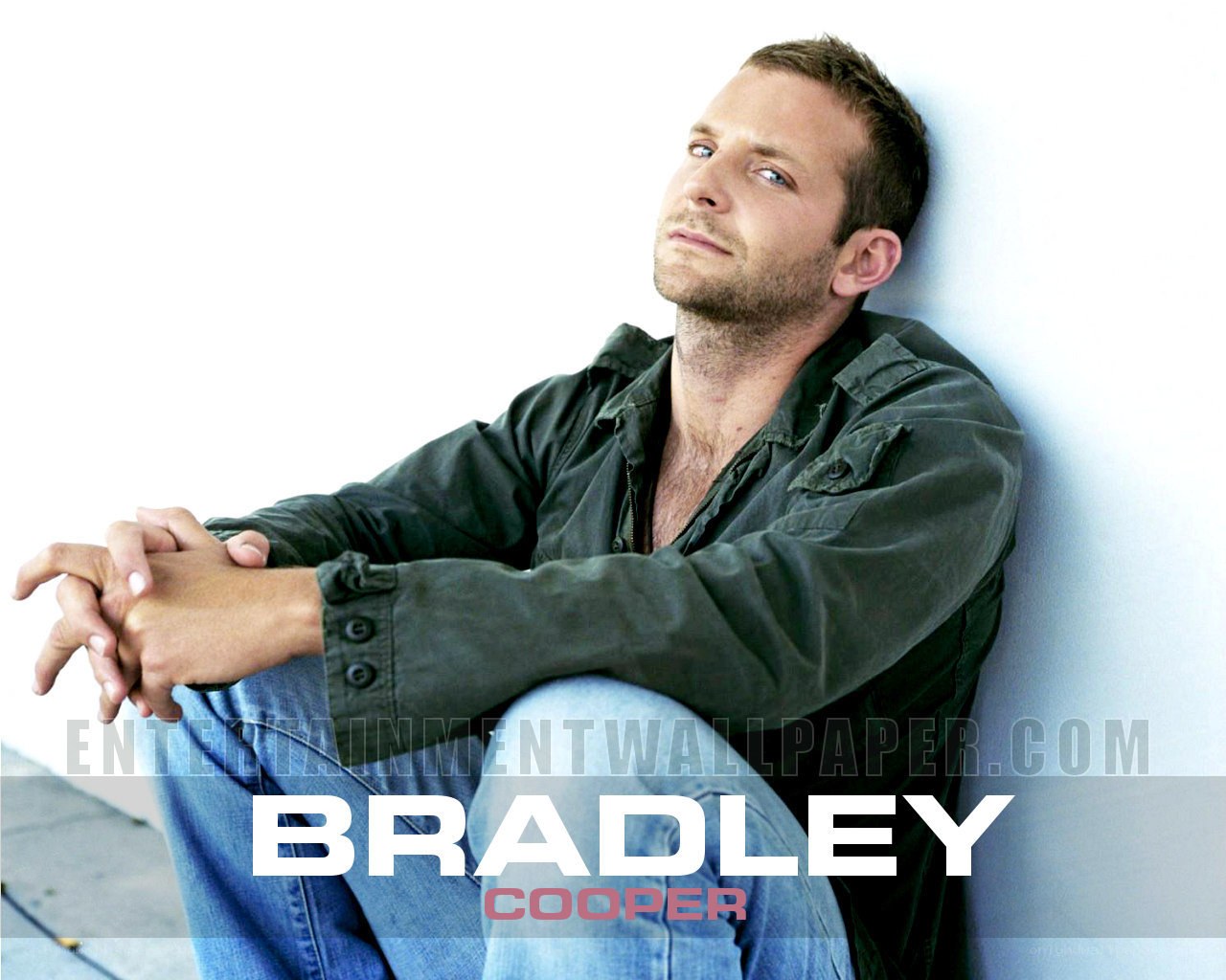 Bradley Cooper sitting against wall