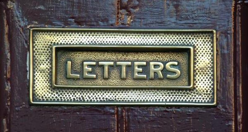 brass letter box on wooden door