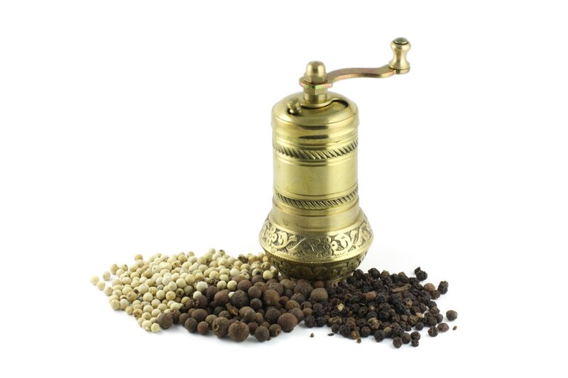 brass pepper mill with peppercorns