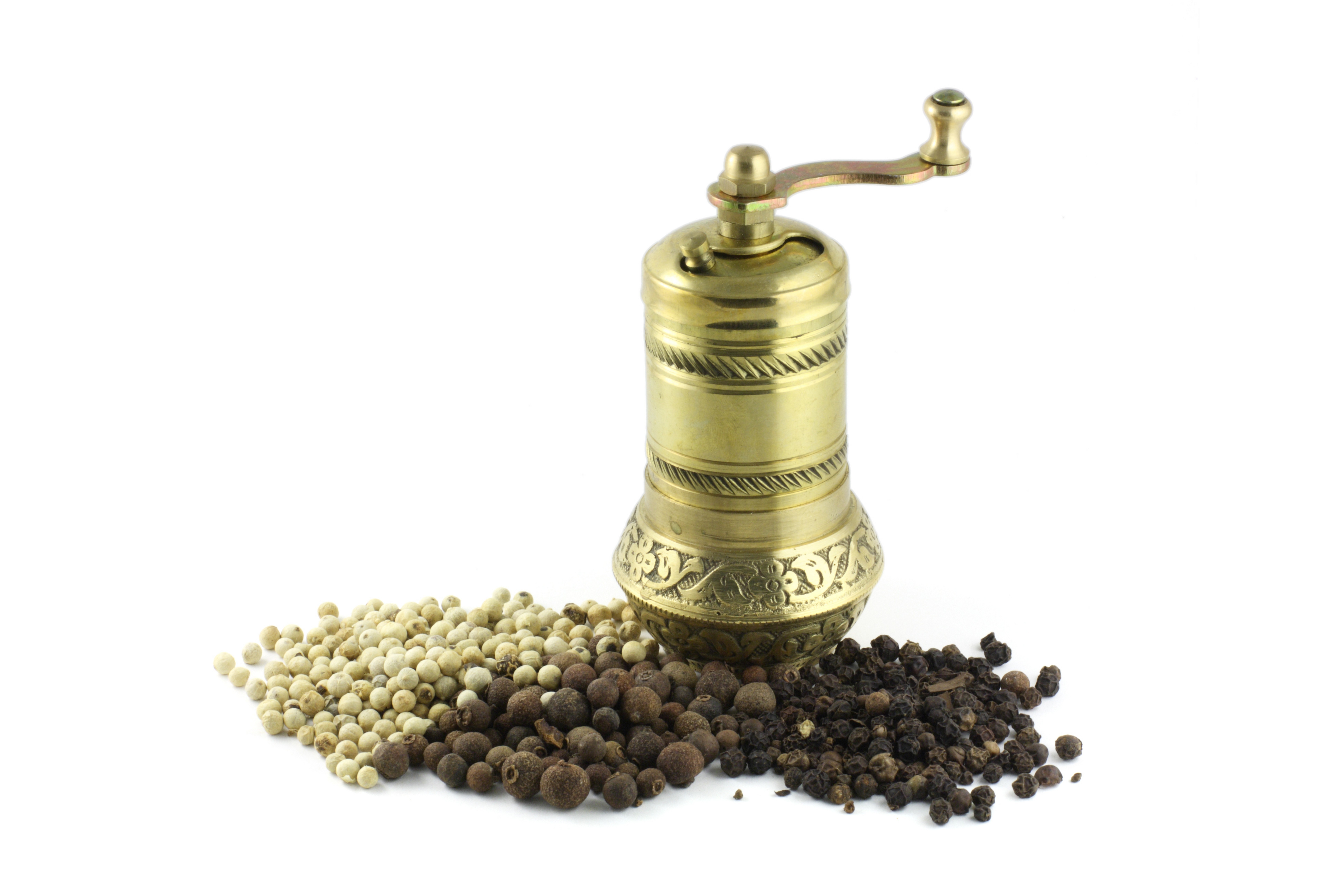 brass pepper mill with peppercorns