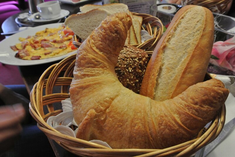 Bread basket with croissant and omelet