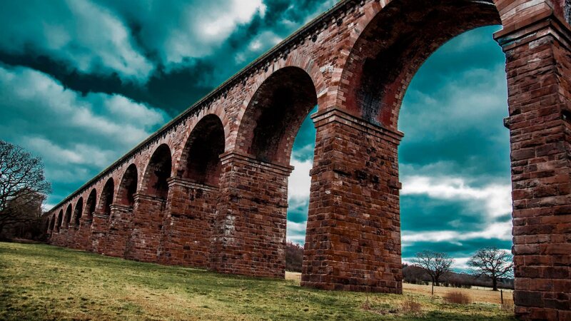 Brick arch viaduct under stormy sky