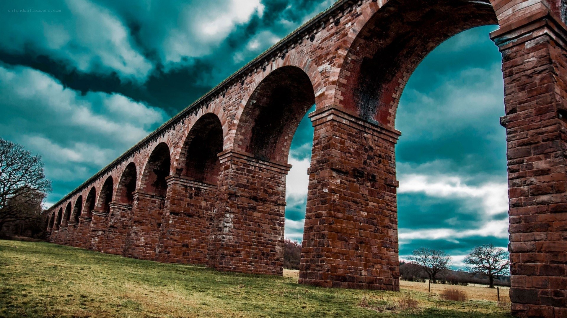 Brick arch viaduct under stormy sky