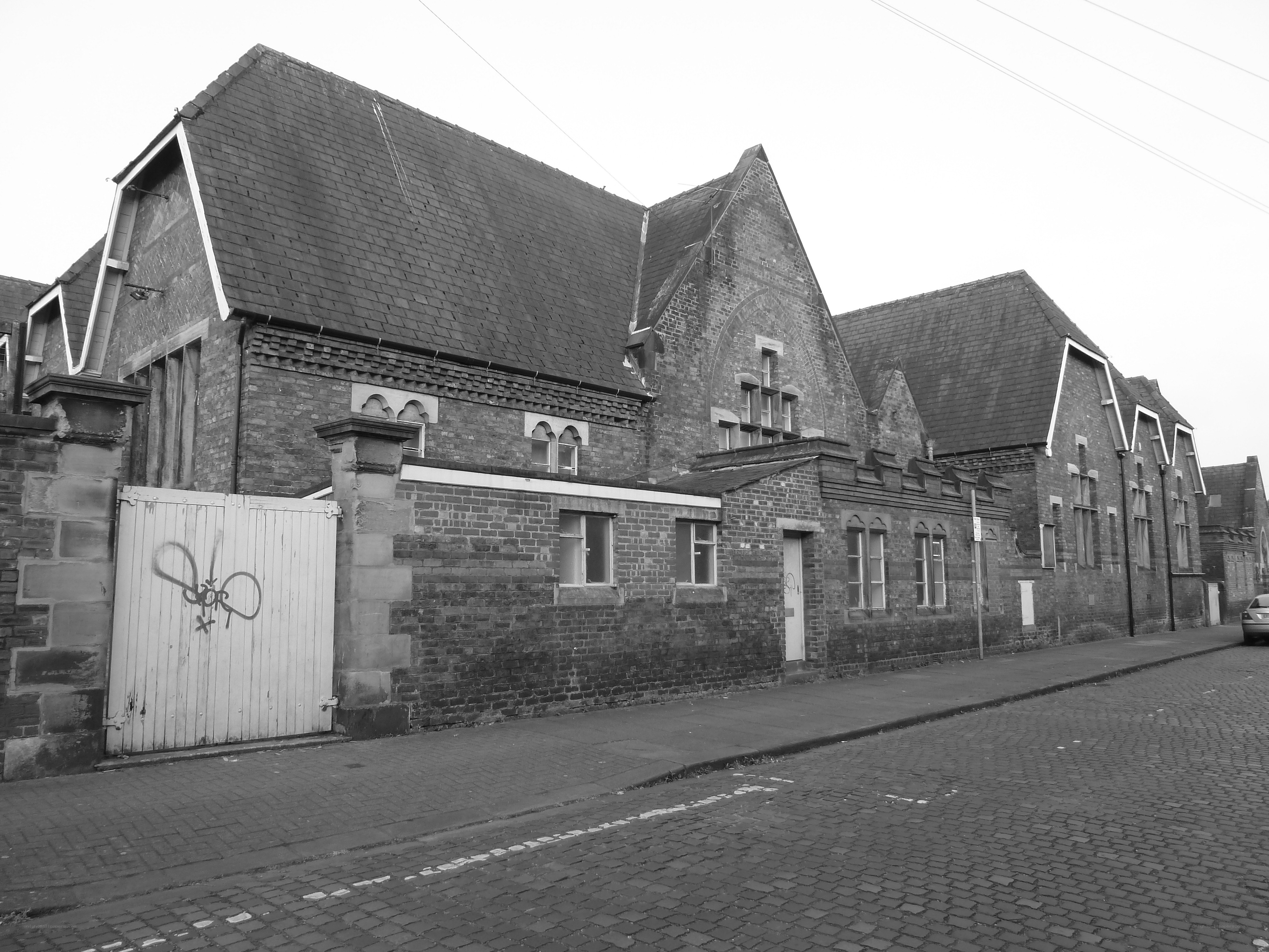 brick building with graffiti gate