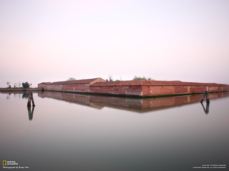 Brick buildings on a calm waterway