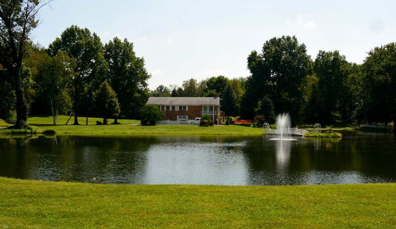Brick House by Pond — Green, Serene, Afternoon