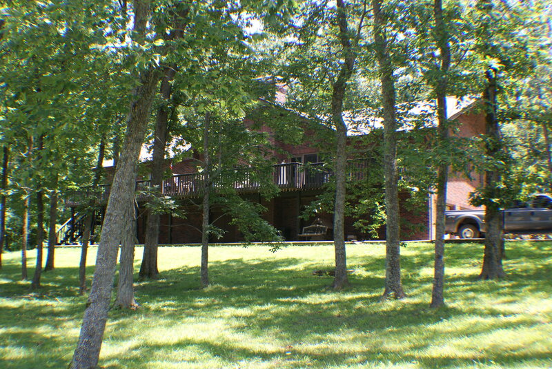 Brick house with deck in wooded area