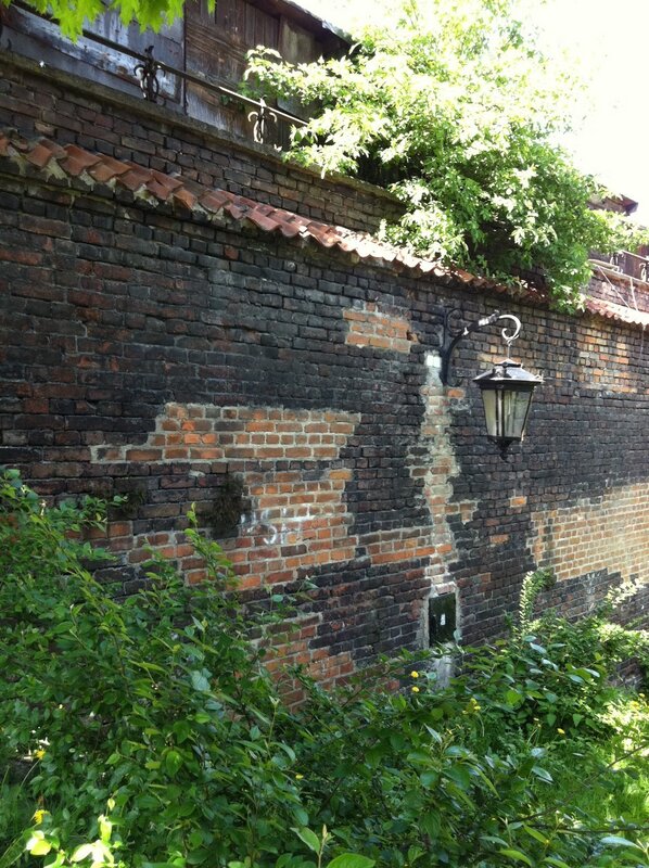 Brick wall with lantern and greenery