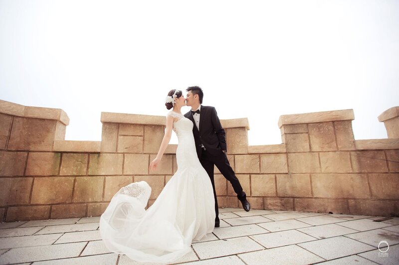 Bride and groom kissing on balcony