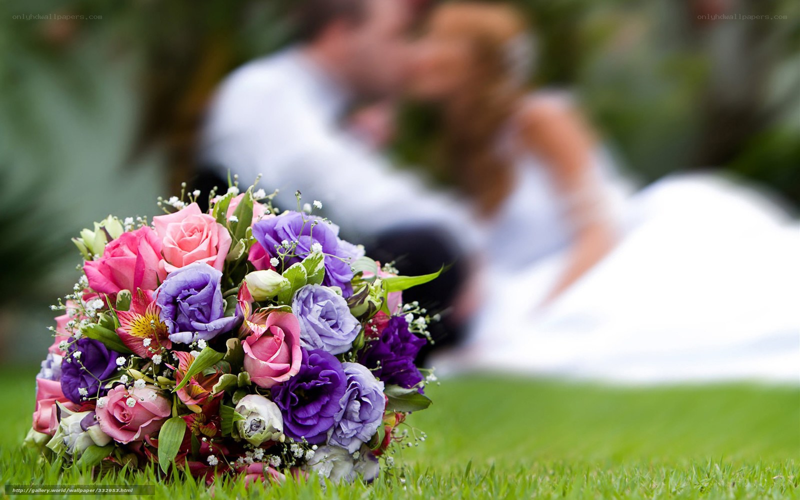 Bride and groom kissing with bouquet