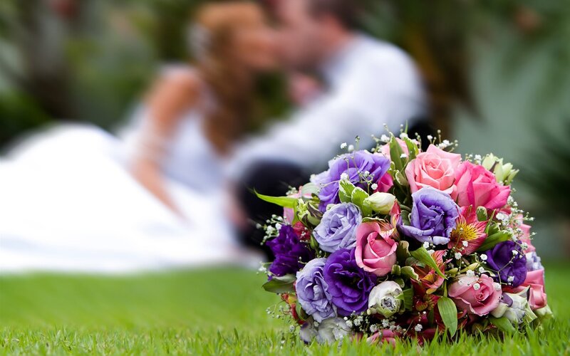 Bride and groom kissing with bouquet