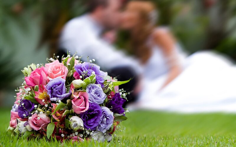 Bride and groom kissing with bouquet