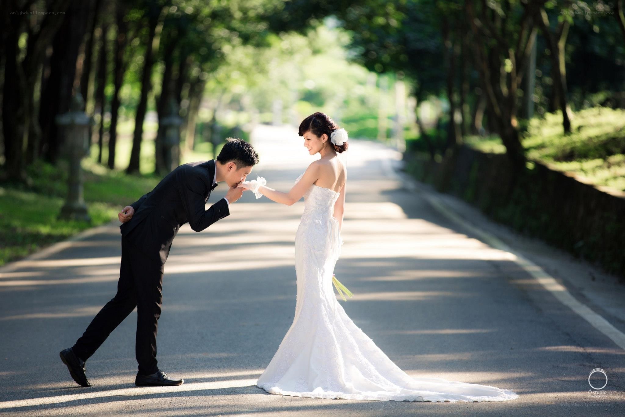 Bride and groom on a tree-lined road