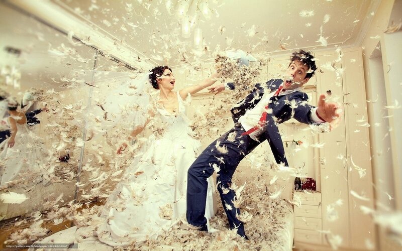 Bride and groom play with feathers