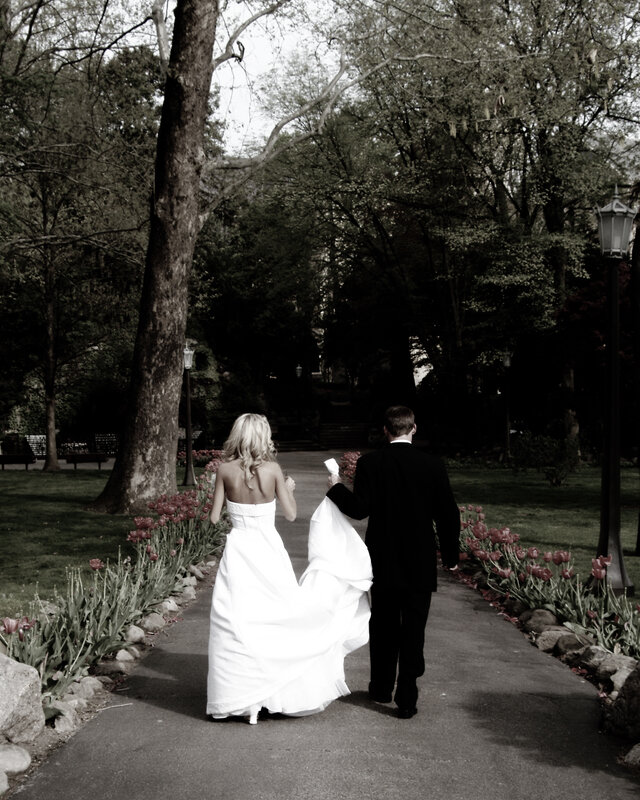 Bride and groom walking in park