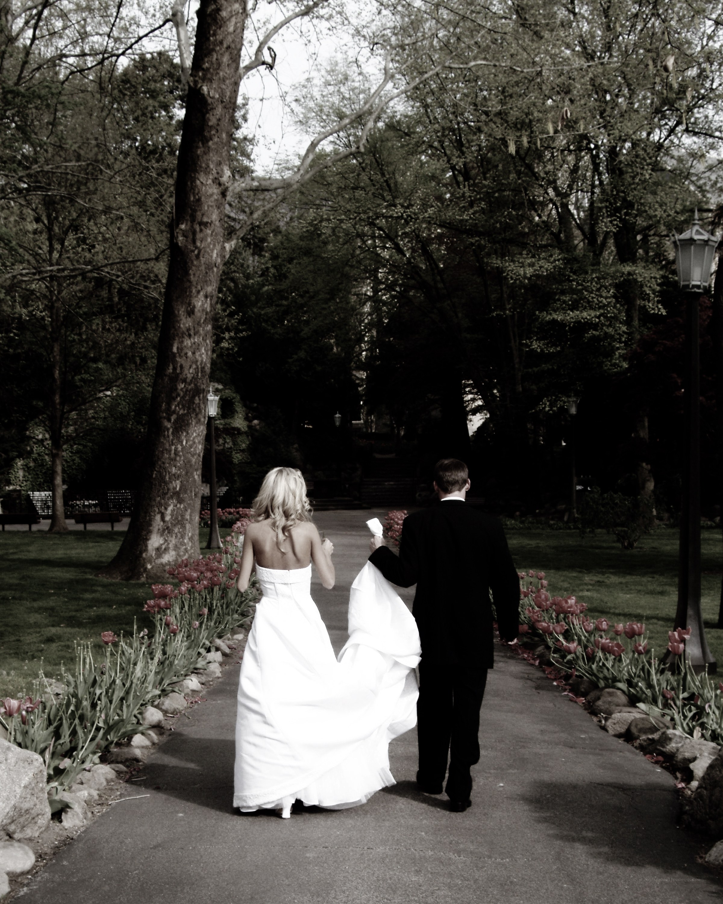 Bride and groom walking in park
