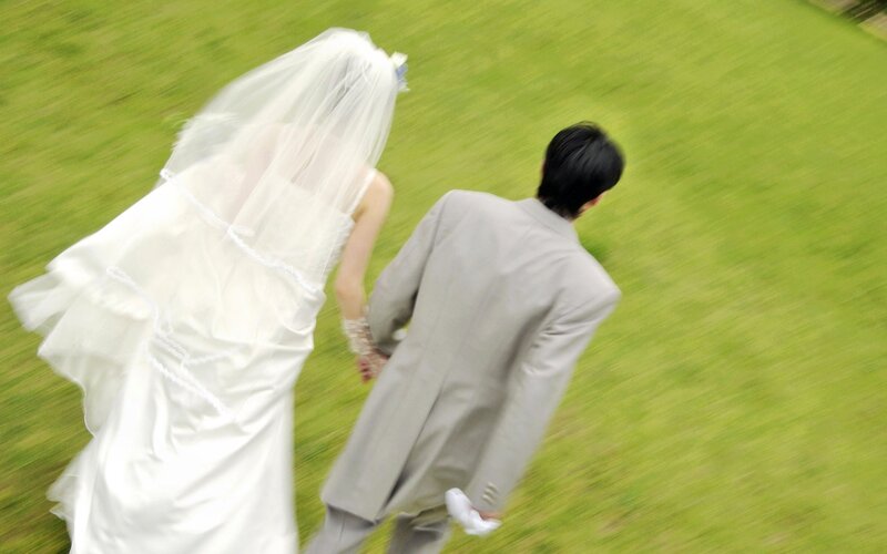 Bride and groom walking on grass