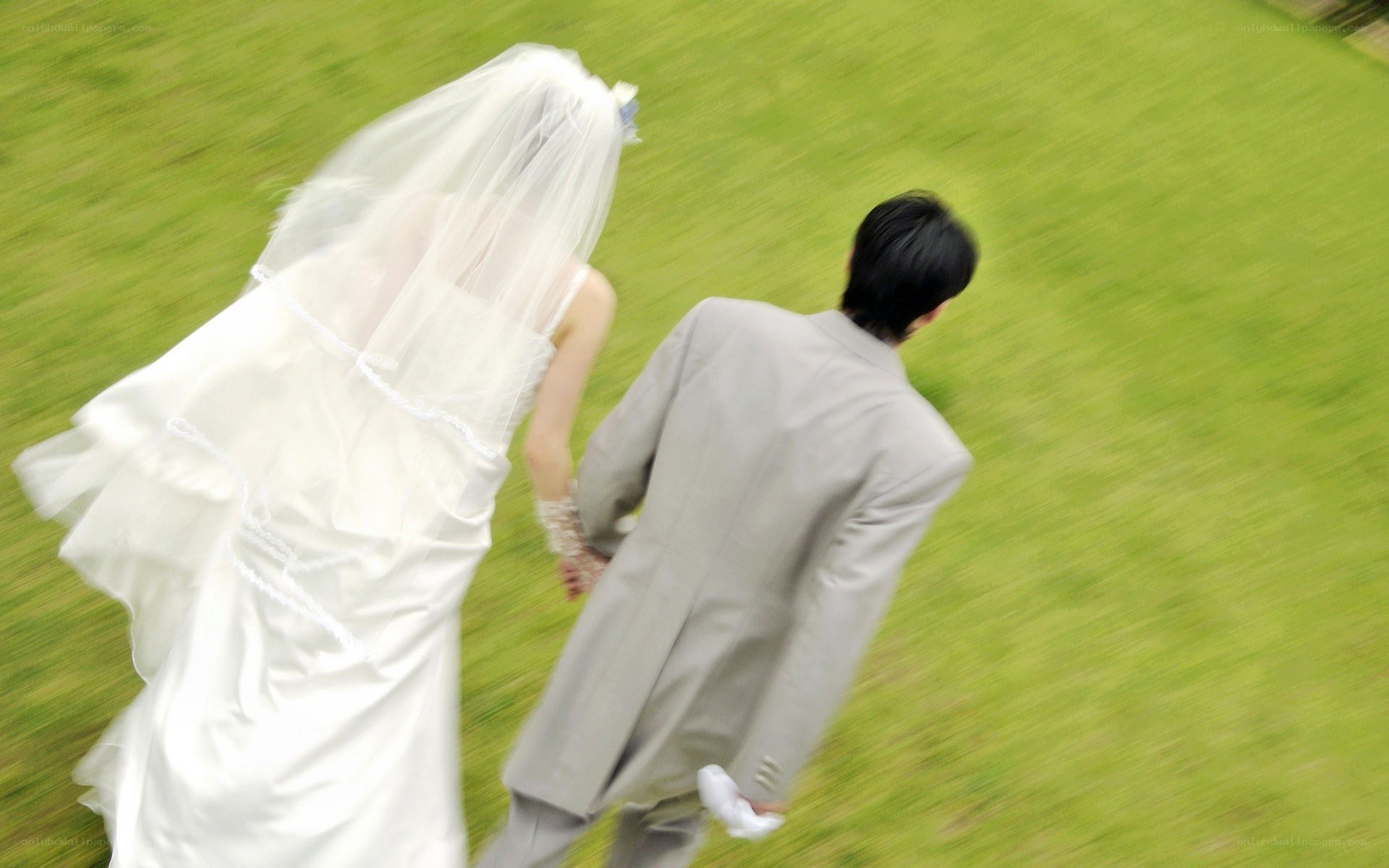 Bride and groom walking on grass