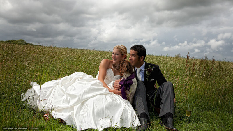 Bride and groom with dog in field