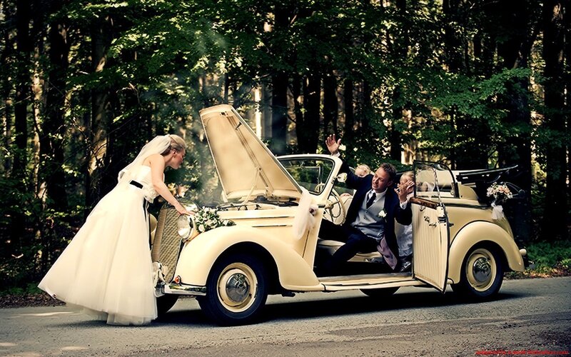 Bride and groom with vintage car