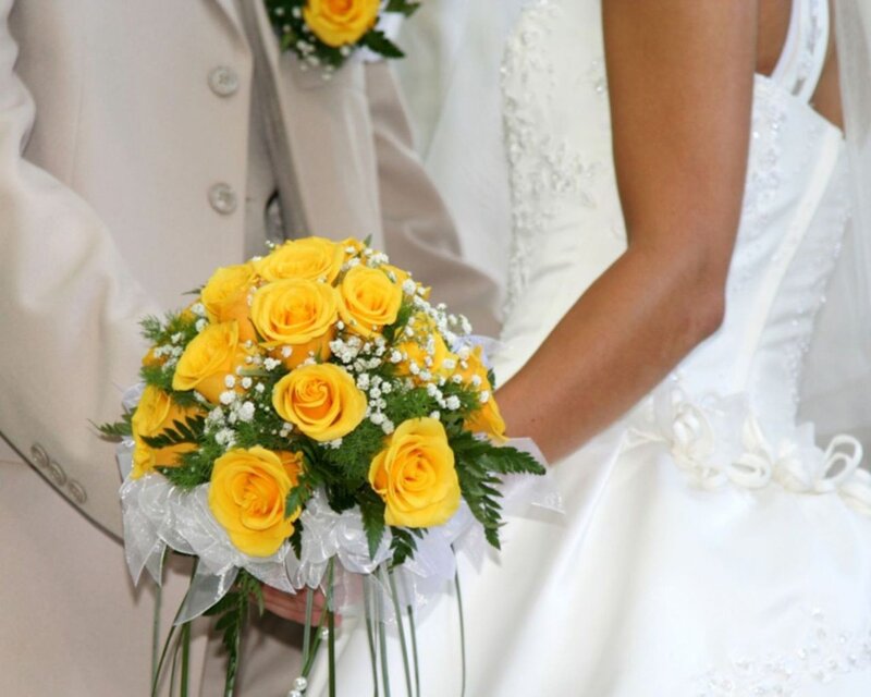 Bride holding yellow roses