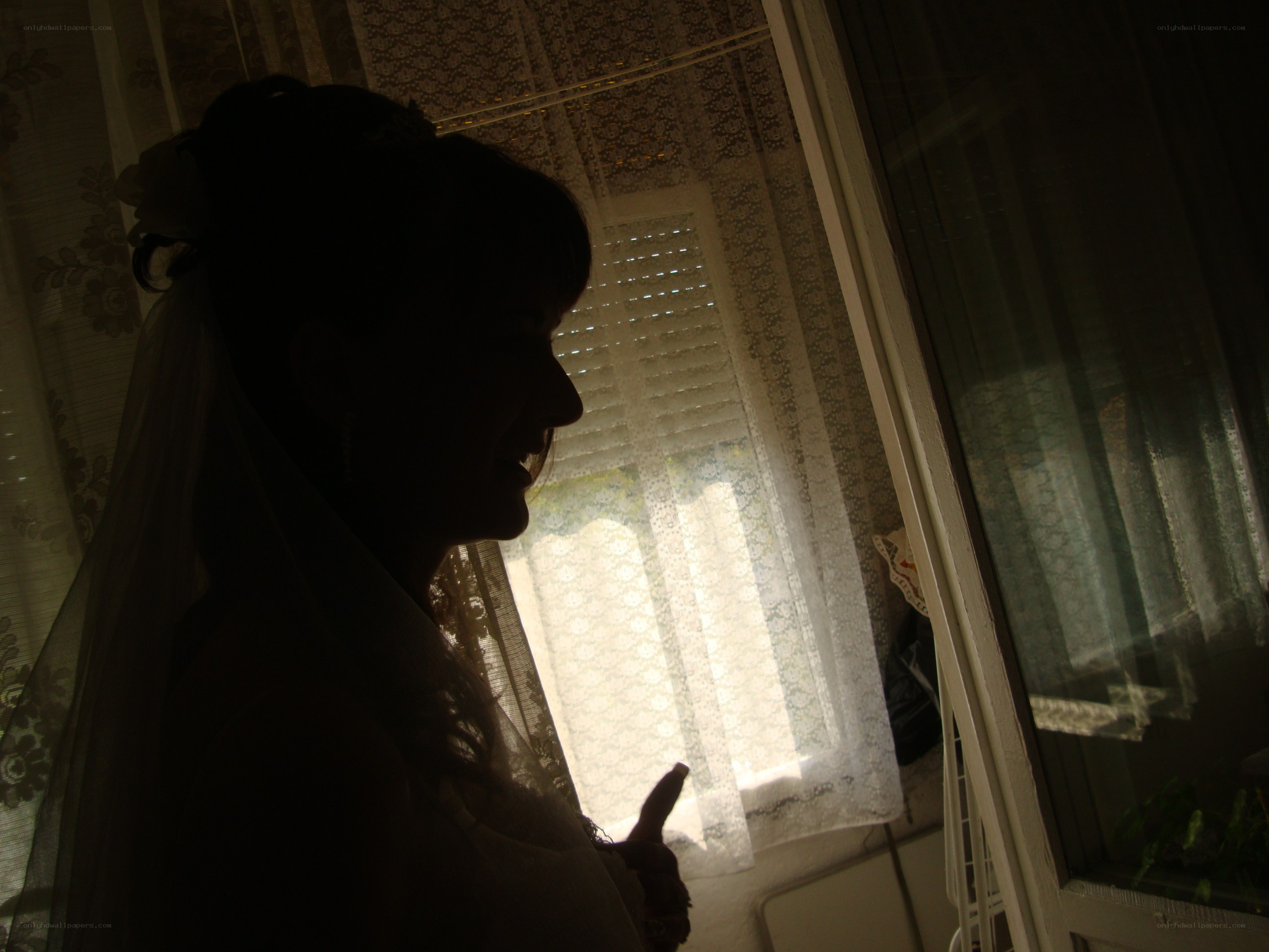 Bride in silhouette by window