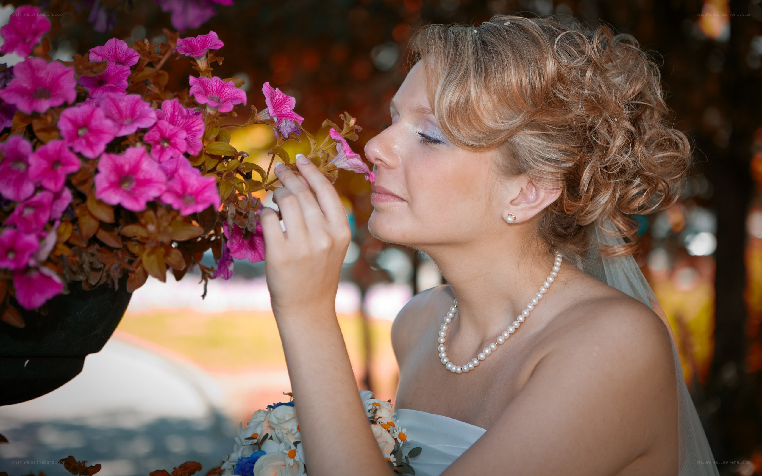 Bride smelling pink flowers