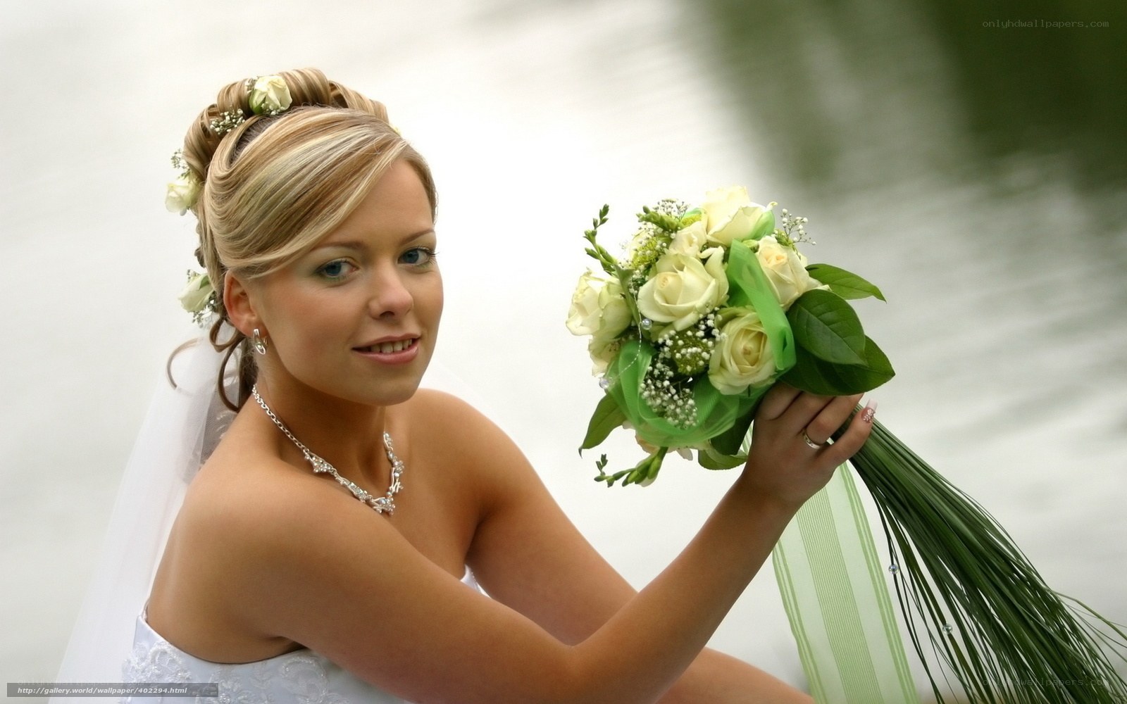 Bride with bouquet by water