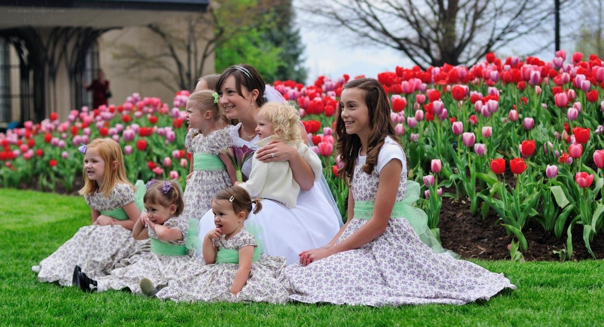 Bride with flower girls in tulip garden