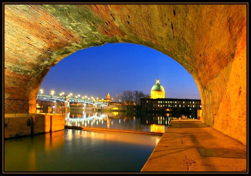 Bridge arch view of city at night