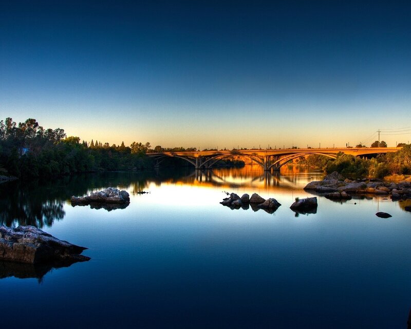 Bridge at sunset over calm river