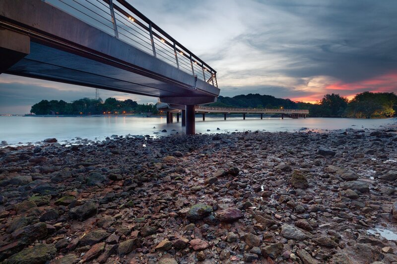Bridge at sunset over rocky shore