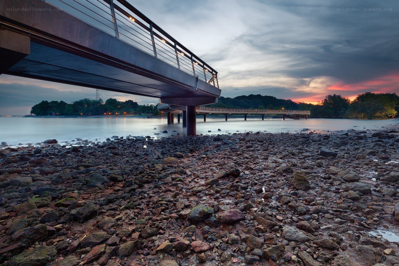 Bridge at sunset over rocky shore