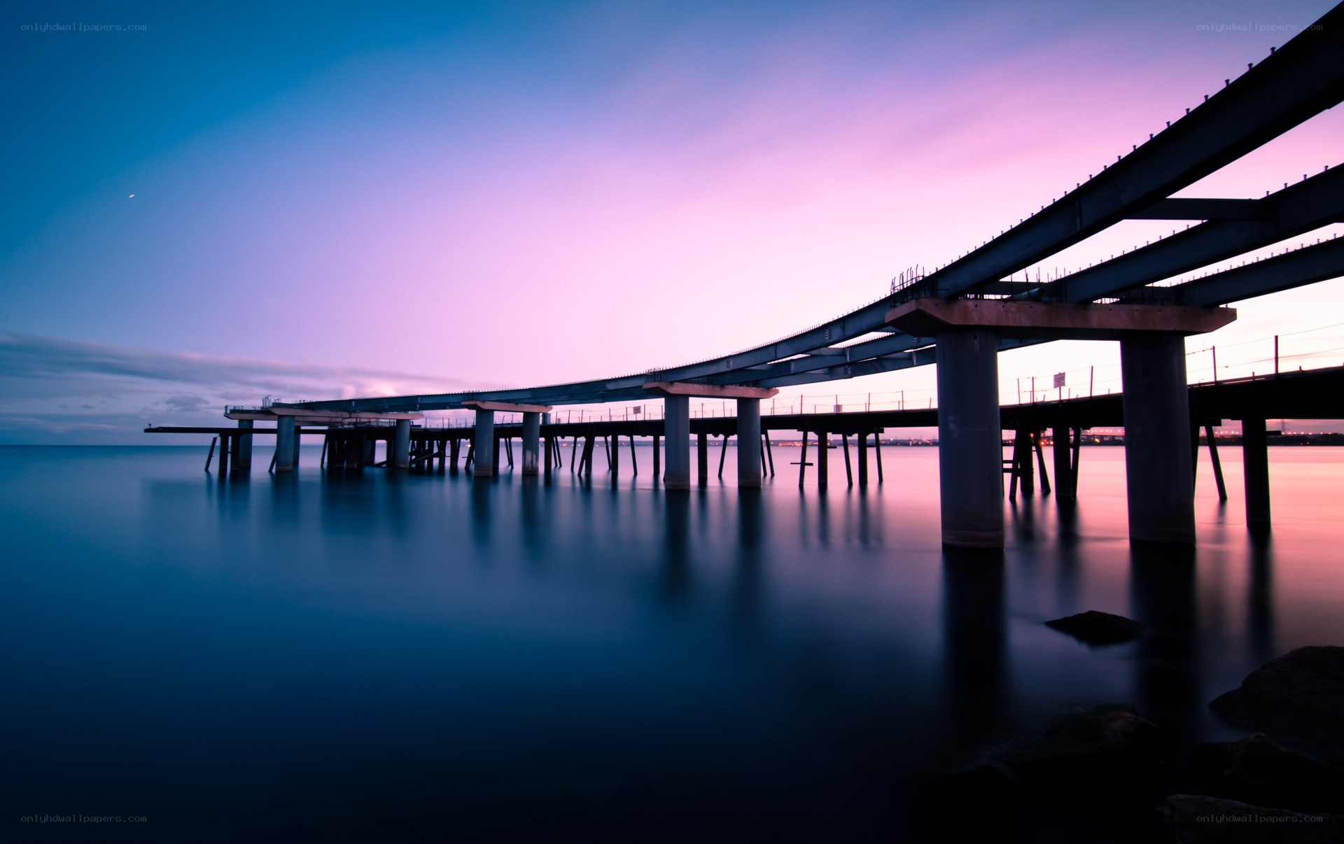 Bridge at twilight over calm water