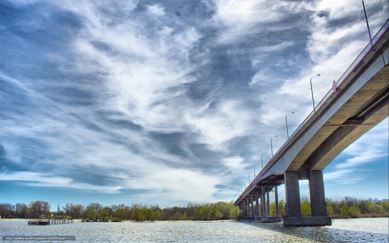Bridge over a river under cloudy sky
