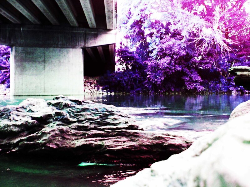 Bridge over a river with purple trees