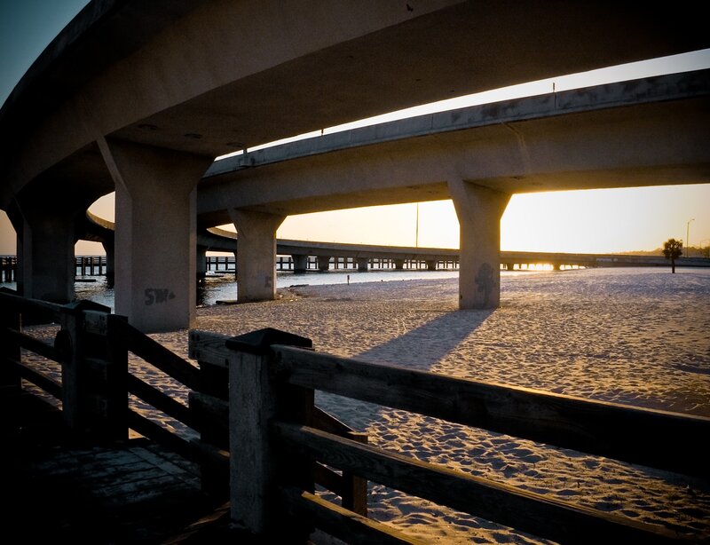 Bridge over beach at sunset