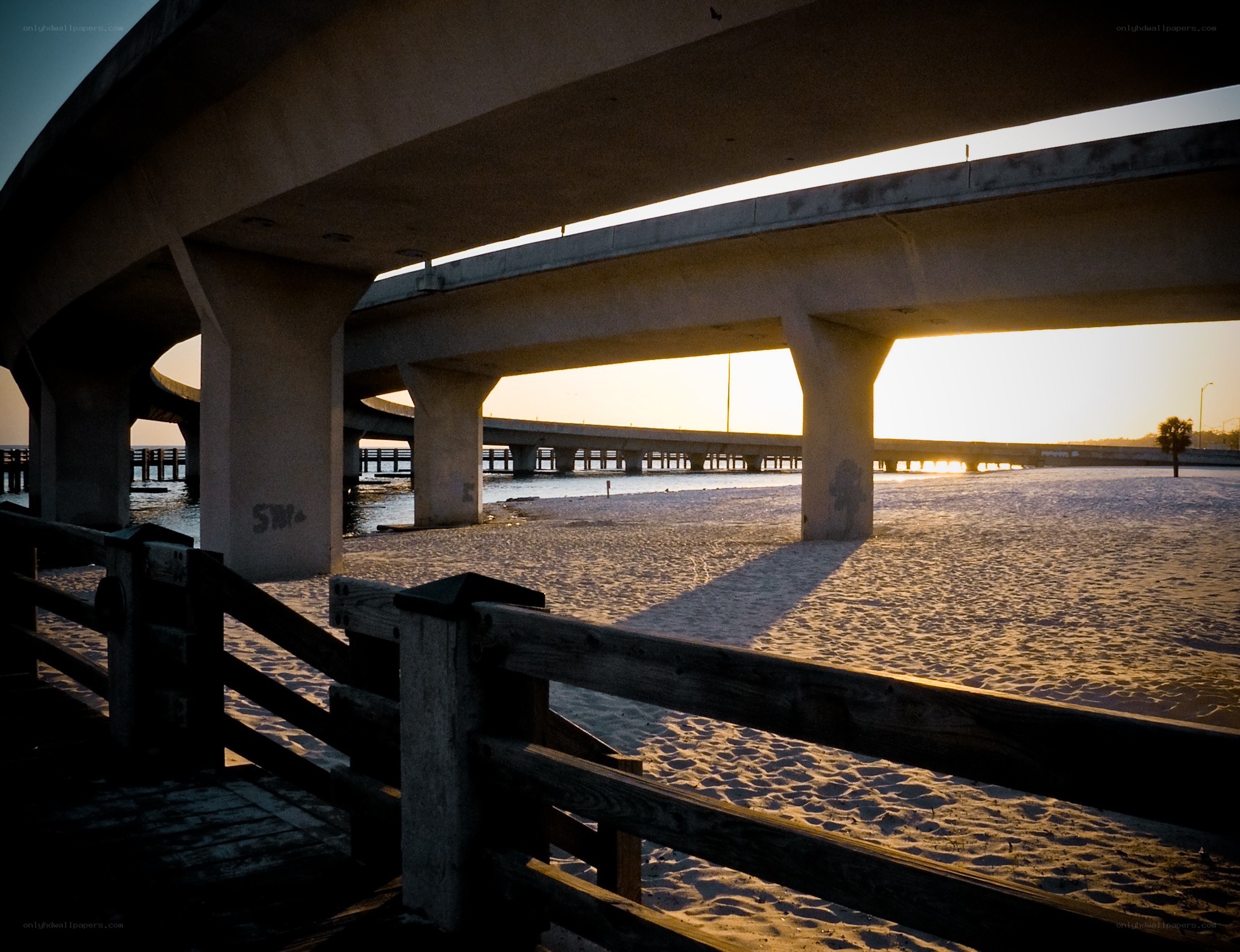 Bridge over beach at sunset