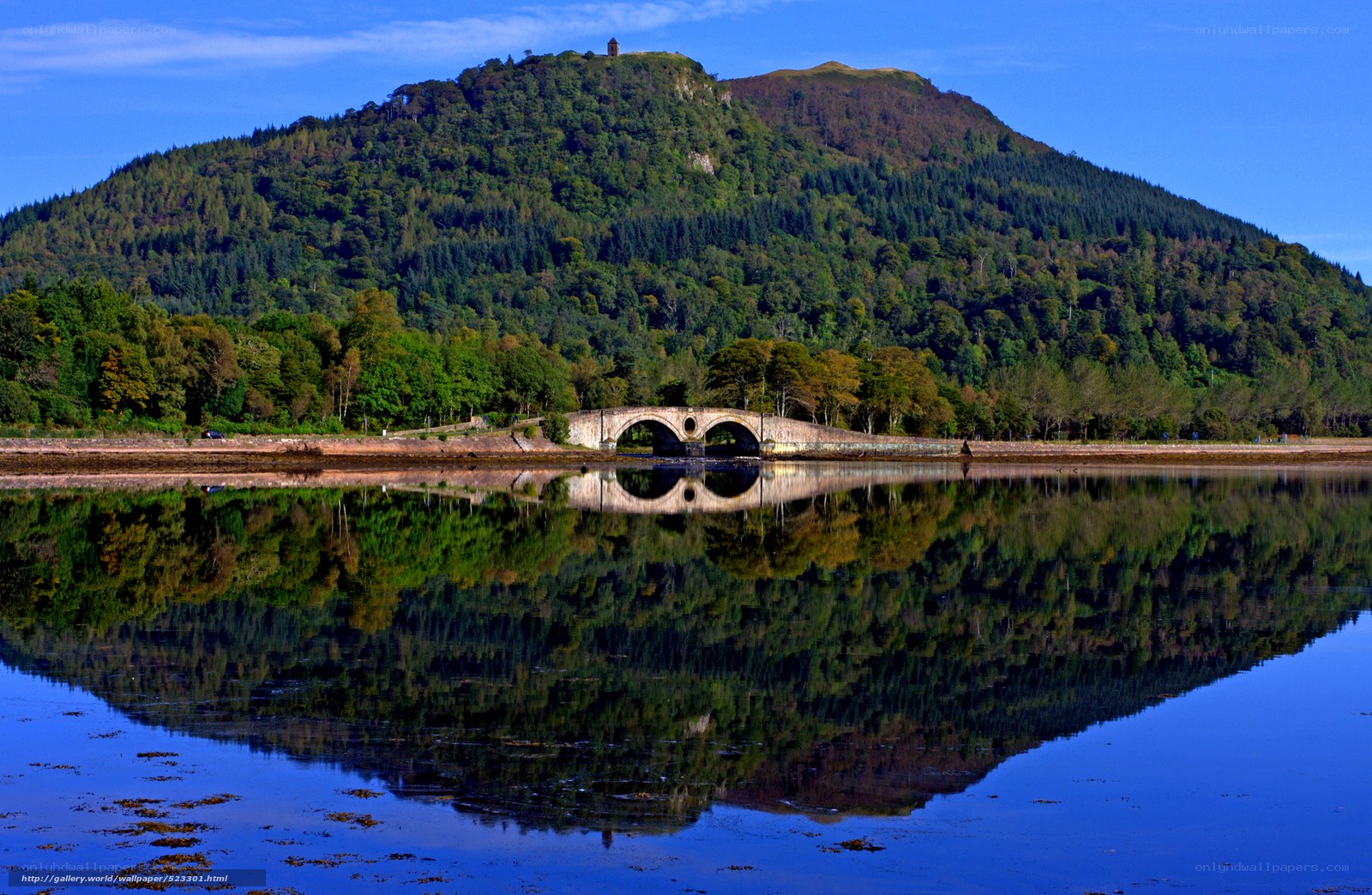 Bridge over calm lake with mountain