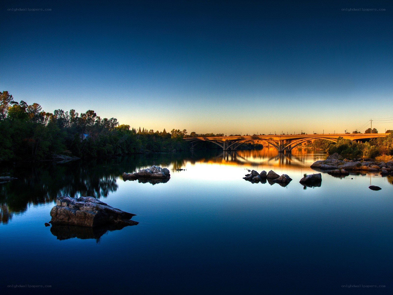 Bridge over calm river at dusk
