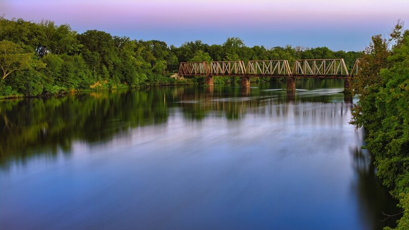 Bridge over calm river at dusk